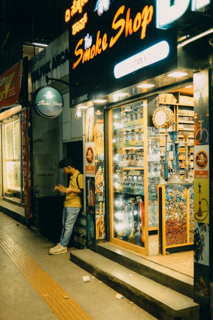 Young Man Leaning in Front of an Illuminated Kiosk